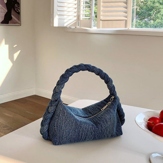 Front view of Blue denim handbag with a unique braided grab handle and a silver zipper, great for everyday carry.