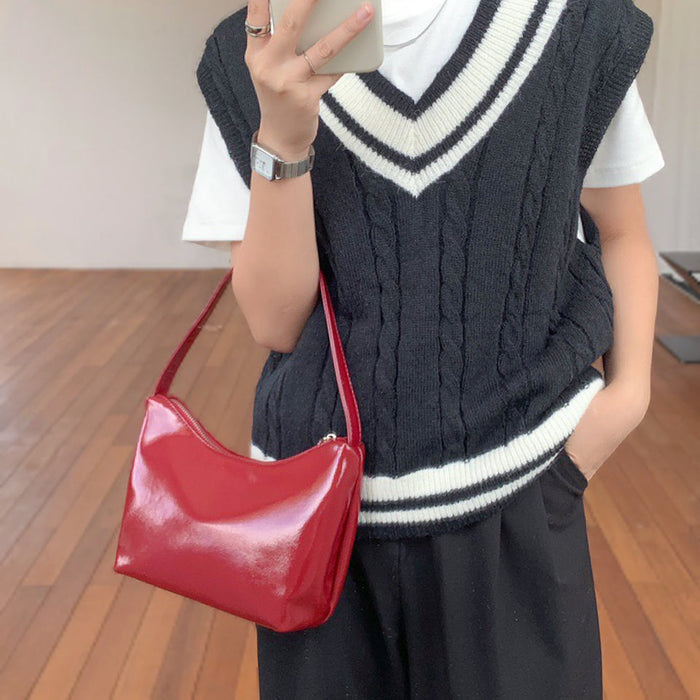 Model wearing the red patent leather shoulder bag as an underarm bag; perfect for retro-chic fashion.