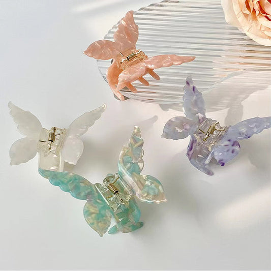 Four acrylic butterfly hair claws in white, pink, purple, and green with alloy springs.