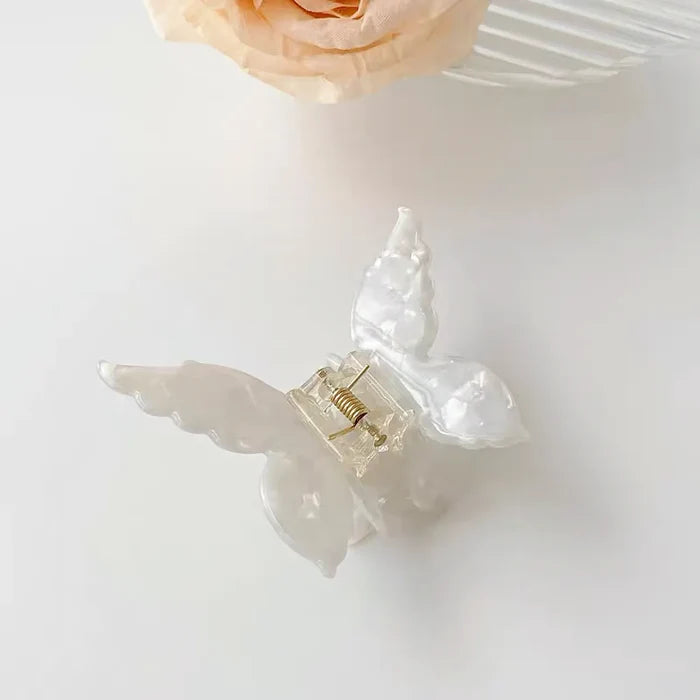 Angled view of butterfly hair claw in white, ideal for quick updos and ponytails.
