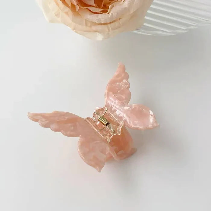 Flat lay of butterfly hair claw  in pink, great for everyday styling and gifting.