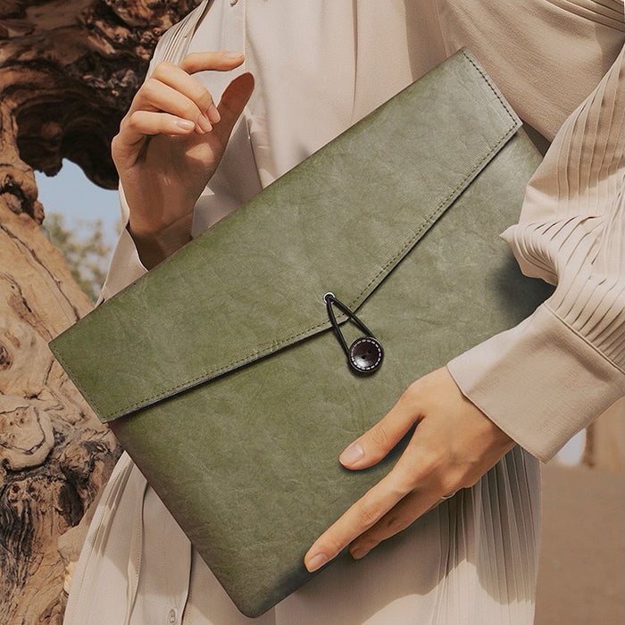 Model carrying a Buttoned Envelope Laptop Sleeve in olive green, easy for commuting and weekends.