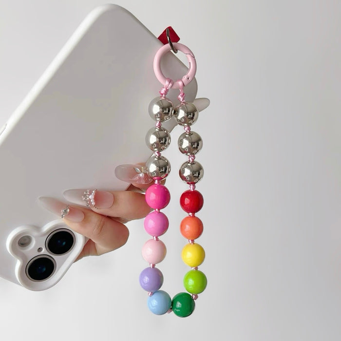 Model holding a phone with  white phone case and rainbow Candy Bead Phone Charm .