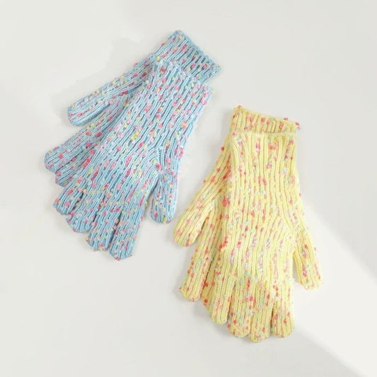 Flat lay candy-dot knit gloves in blue and yellow with speckled bobble dots and ribbed cuffs; cozy winter wear.
