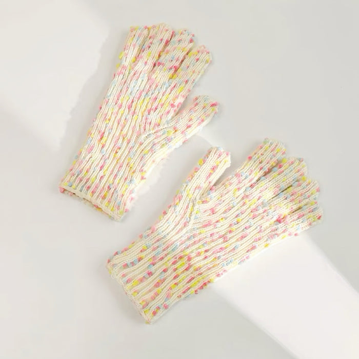 Flat lay of cream candy-dot knit gloves with colorful bobble dots and ribbed cuffs; warm everyday winter wear.