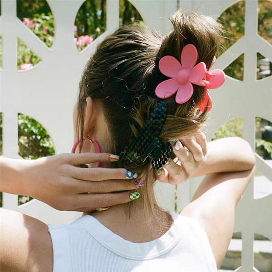 Model wearing a Pink acrylic flower hair claw, showcasing vacation style.