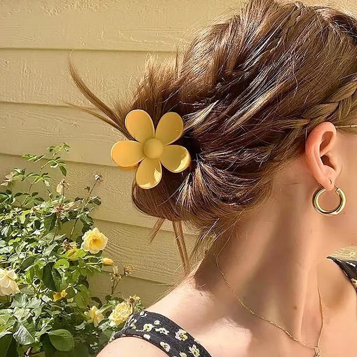 Model wearing a  Candy Flower Hair Claw in yellow, easy for workdays and special occasions.