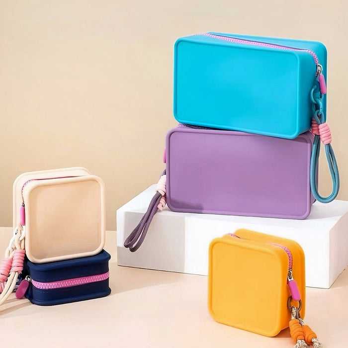 Stack of cyan, purple, light khaki, navy blue and yellow matte silicone toiletry bags showcasing their soft-touch compact structure.