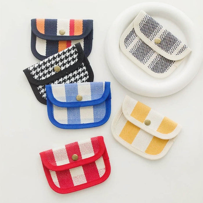 Canvas coin purses in mixed patterns—stripes, gingham, houndstooth, leopard—snap-flap mini wallets for coins/cards.