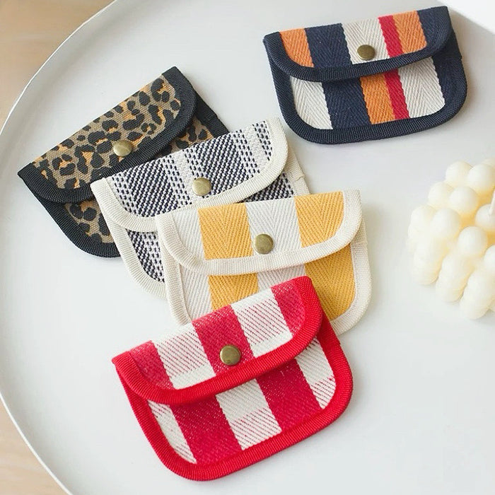 Assorted canvas coin purses with snap flap: red stripe, yellow gingham, leopard, and plaid patterns for small cash.