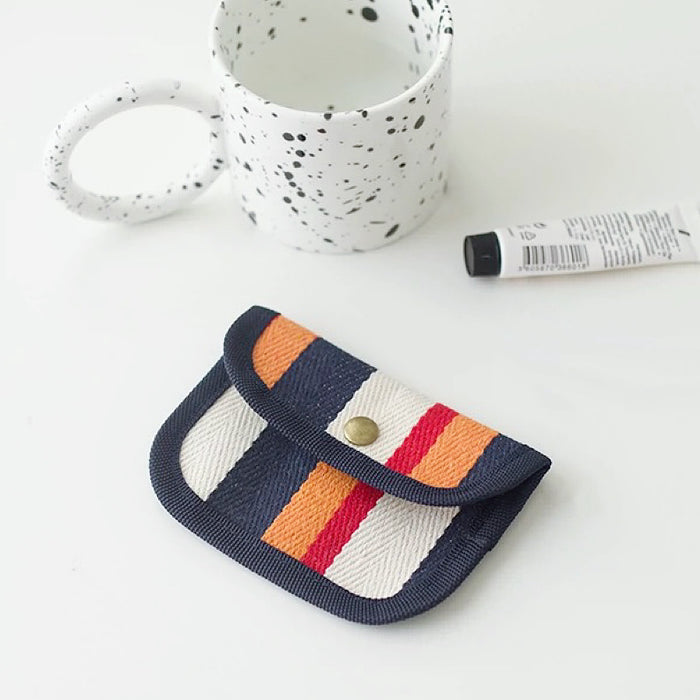 Canvas coin purse with navy trim and orange/white stripes; snap-flap mini wallet for coins and daily cards.