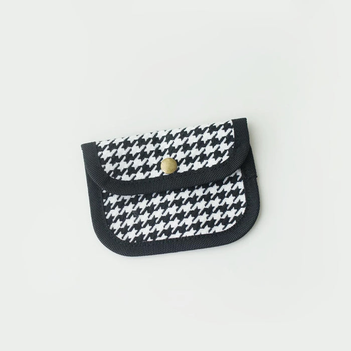 Houndstooth canvas coin purse with black trim and snap button; compact coin and card holder.