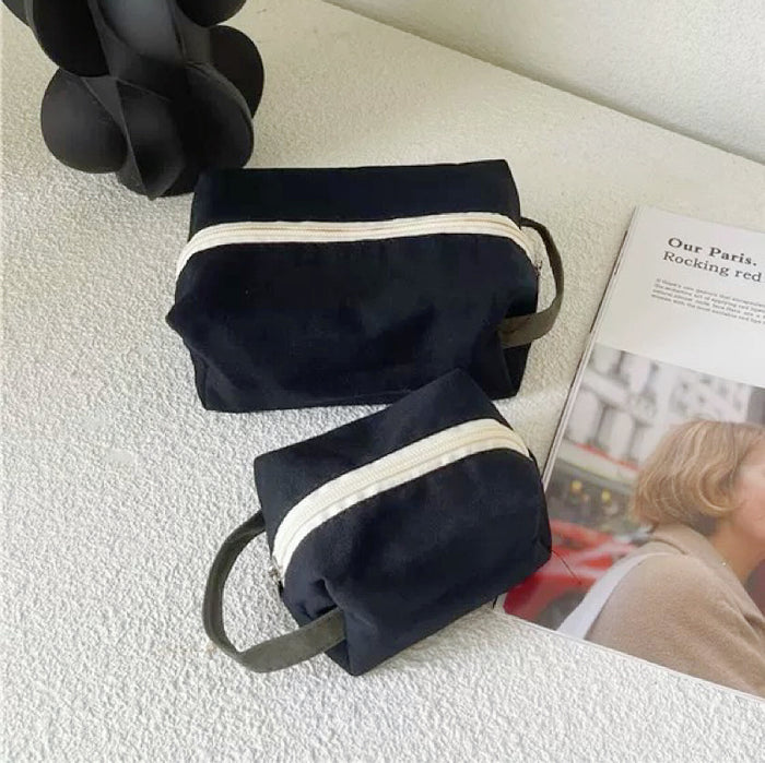 Two black canvas makeup bags in different sizes; minimalist design for everyday utility.