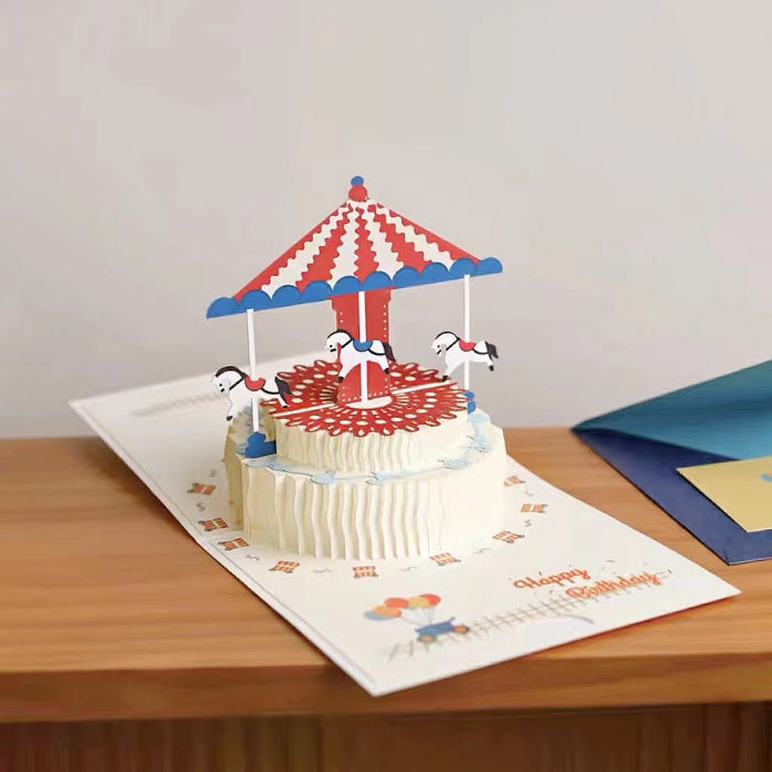 Front view of Pop-up carousel greetings card with red and white striped canopy, white horses, and Happy Birthday text.