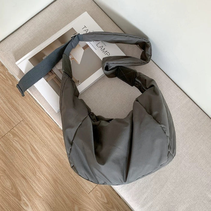 Dark grey crescent bag with a soft, padded silhouette and durable nylon texture.