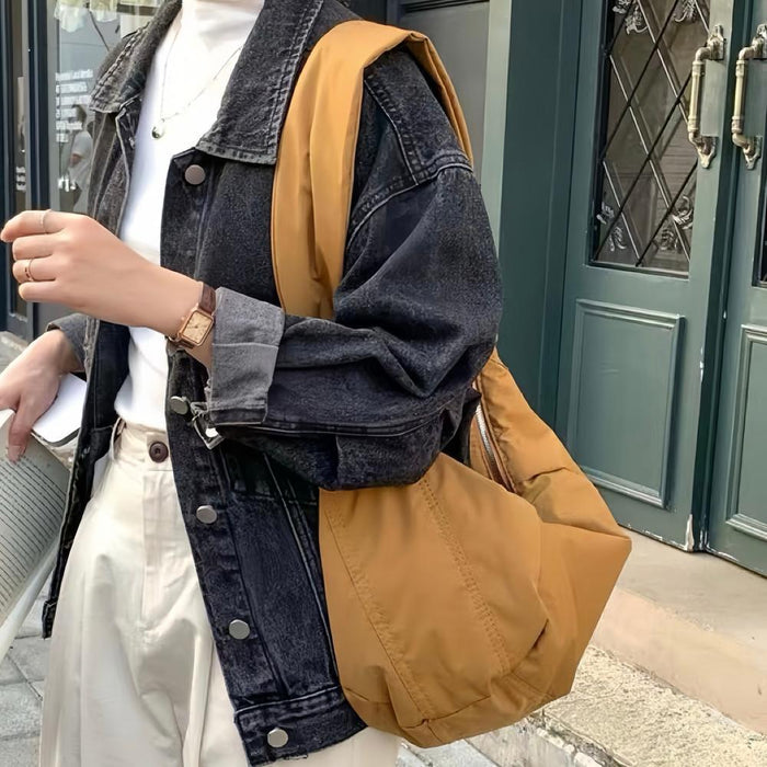 Camel brown padded bag paired with a denim jacket, showcasing a relaxed urban casual style.