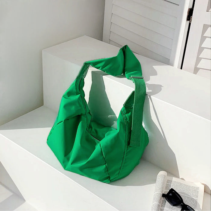 Vibrant green crescent bag with a cushioned texture, adding a pop of color to minimalist outfits.