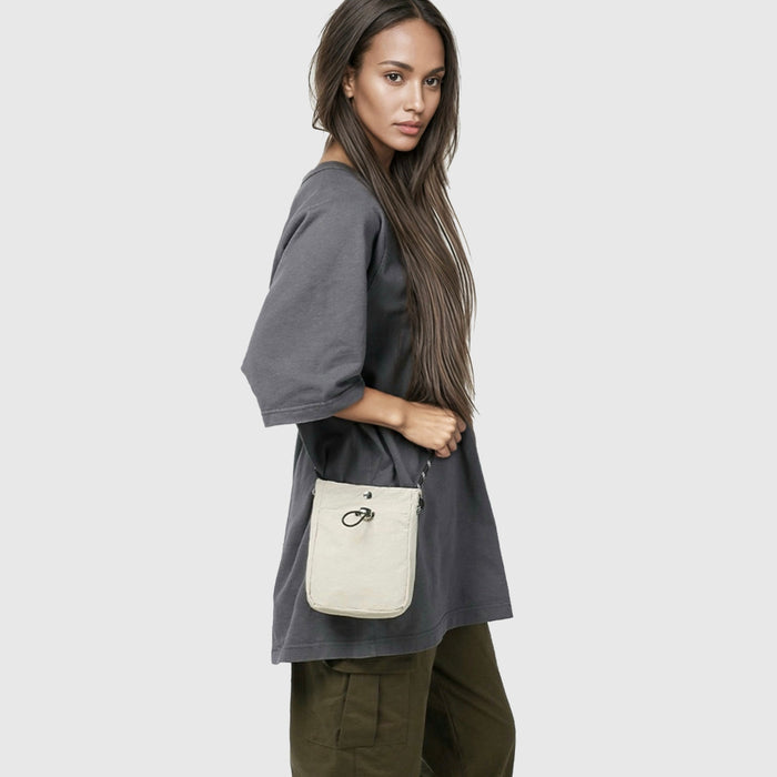 Model carrying a beige mini bag as crossbody, great for daily carry and travel.