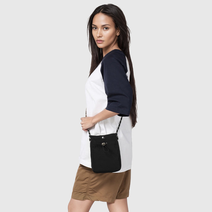Model carrying a black mini bag as crossbody, easy for commuting and weekends.