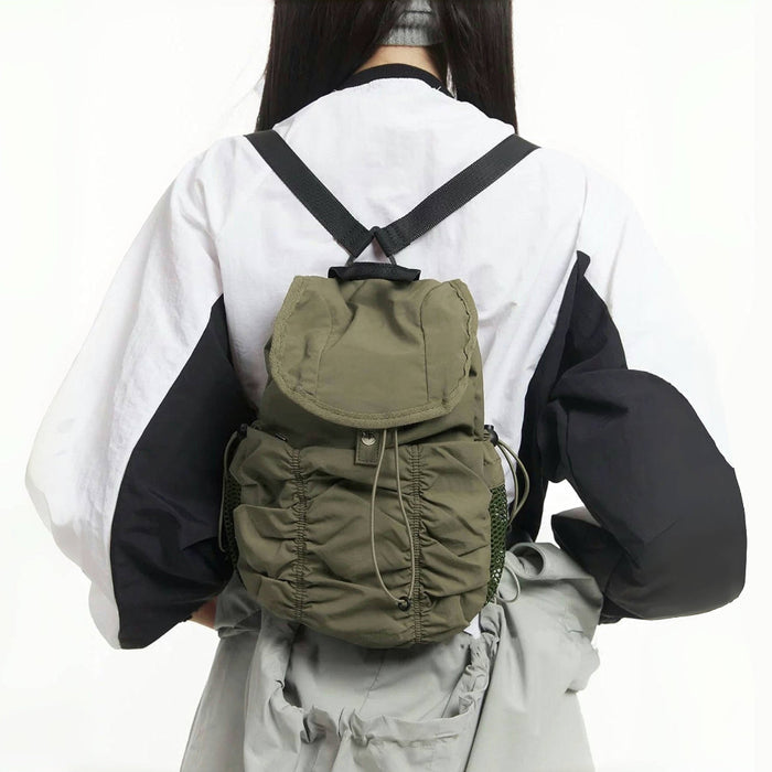 Back view of model with olive pleated backpack; ergonomic design ideal for comfortable daily commuting.