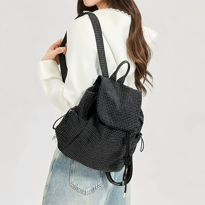 Model carrying a  black Check Mate Mini Backpack on her shoulder, easy for commuting and weekends.