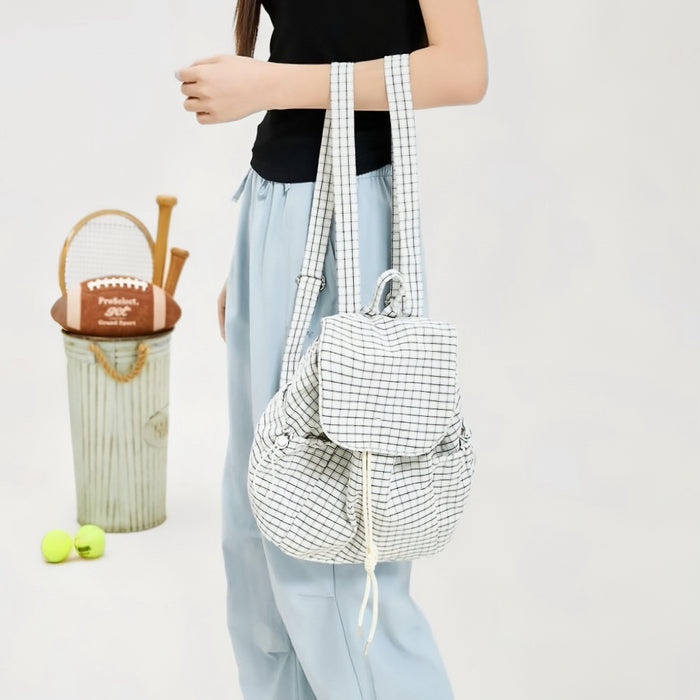 Model holding a white Check Mate Mini Backpack, ideal for city walks and gifting.