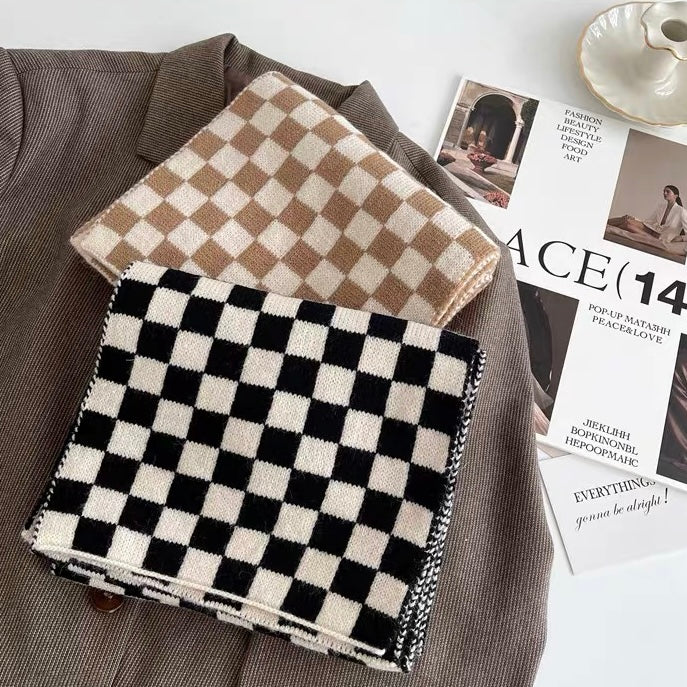 Two wool-blend checkerboard scarves, one black and white, one beige and white, on a brown jacket.