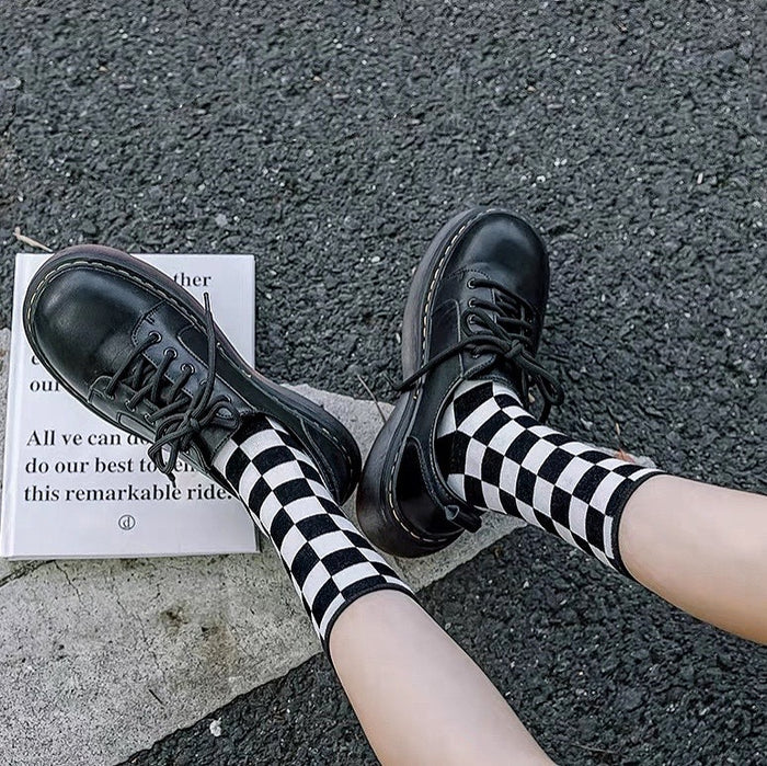 Model wearing a pair of black plaid cotton socks, great for casual wear and light workouts.