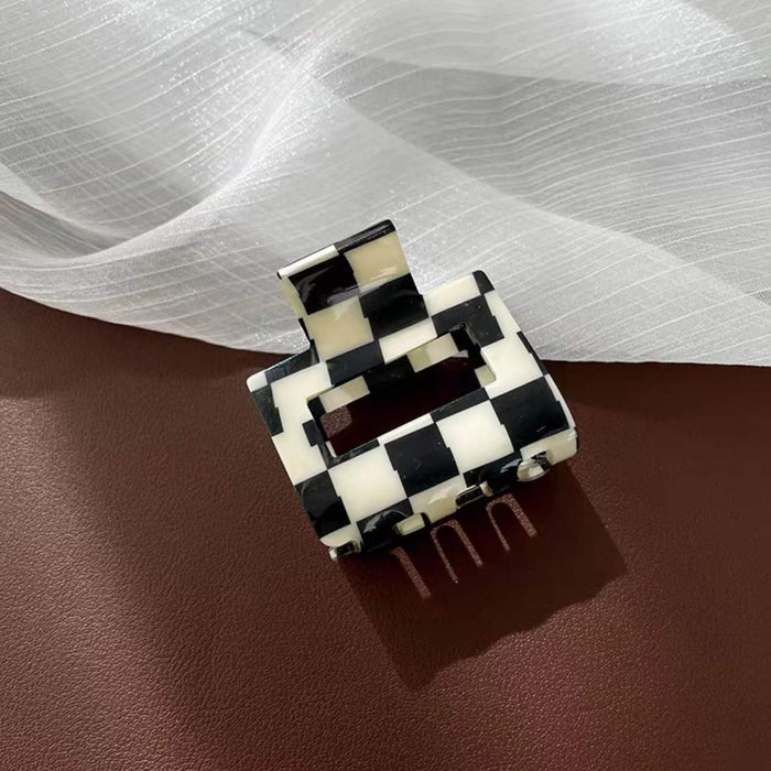 Angled view of checkerboard hair claw in cube shape, ideal for quick updos and ponytails.
