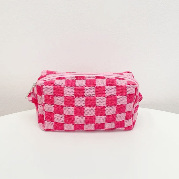 Front view of a hot pink checkerboard knit bag; soft textured crochet pouch for retro-modern style.