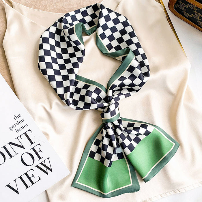 Model wearing Checkerboard satin skinny scarf in black, white, and green, tied on a cream top, ideal for daily wear.