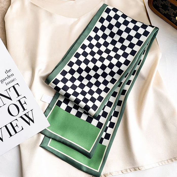 Model wearing a Green and white checkerboard satin skinny scarf on a light top, great for office.