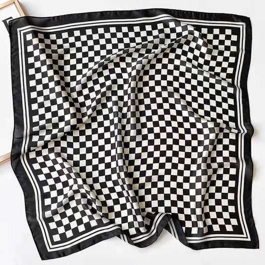 The black and white checkerboard scarf spread out flat to show its full square design.