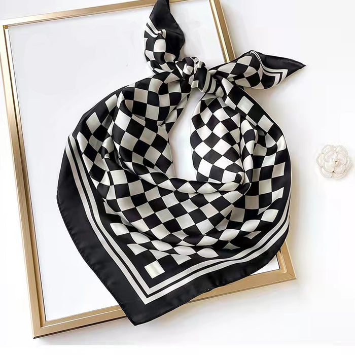 A black and white checkerboard scarf tied into a decorative bow.