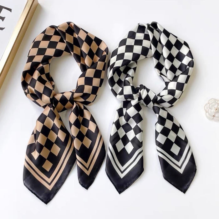 Two satin checkerboard square scarves, one black and white, one black and caramel, tied neatly.