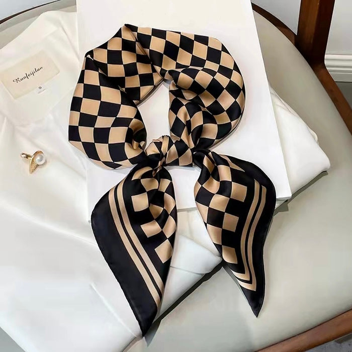 The caramel and black checkerboard scarf tied into a bow.