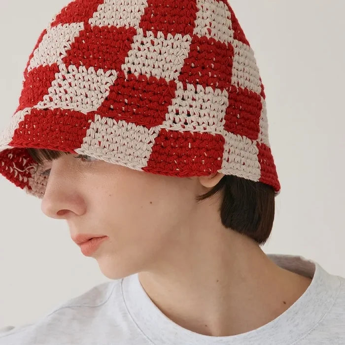 Model wearing red checkered crochet bucket hat, highlighting a vibrant color and breathable knit.