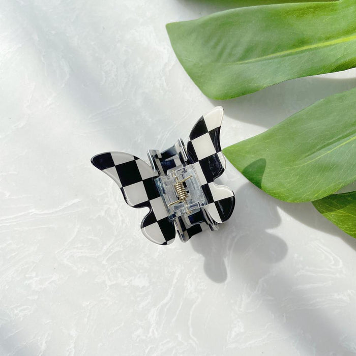 Folded view of checkered hair claw in butterfly shape , ideal for quick updos and ponytails.