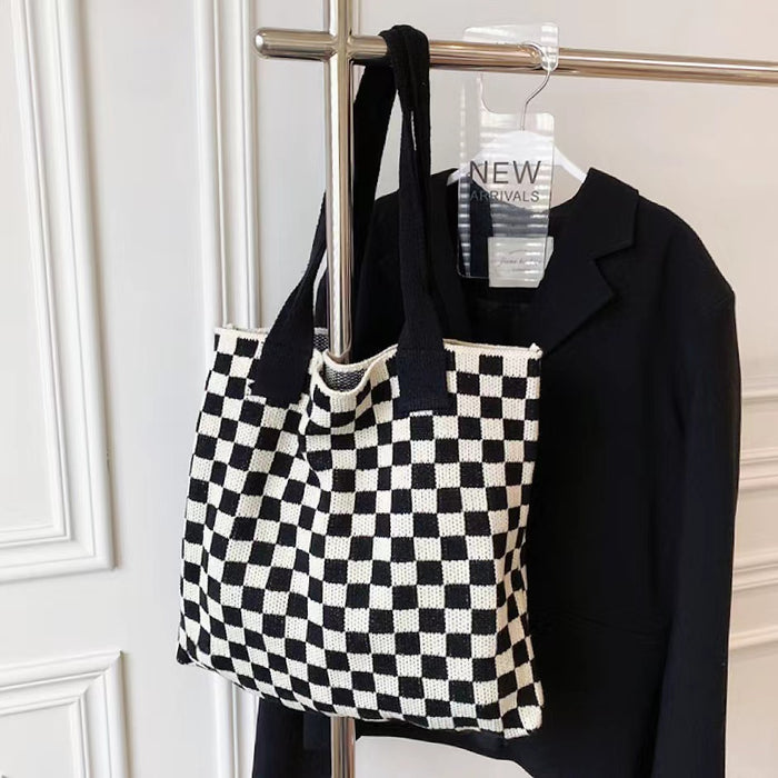 Black and white checkered knit tote hanging on a rack, perfect for a minimalist wardrobe.