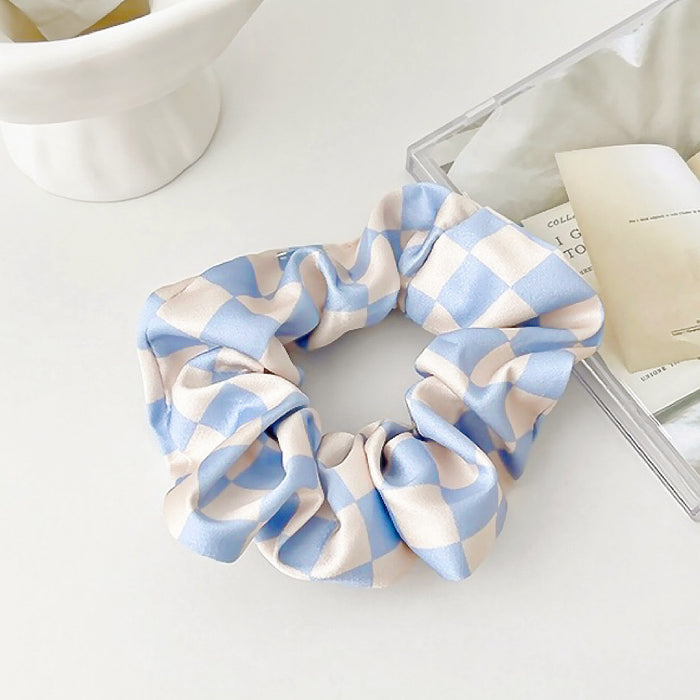 Front view of checkerboard satin scrunchie in blue, easy for workdays and special occasions.