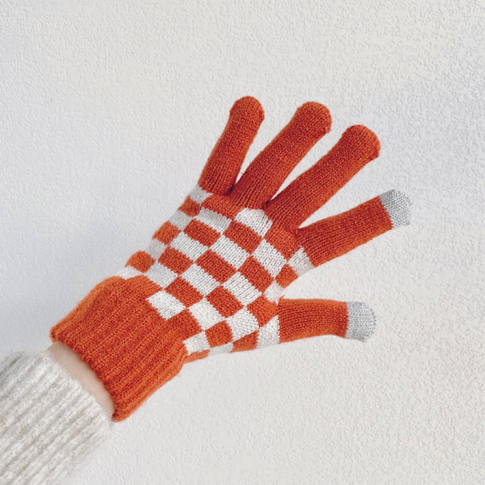 Close-up checkerboard knitted touch screen gloves with contrasting squares; cozy winter accessory.