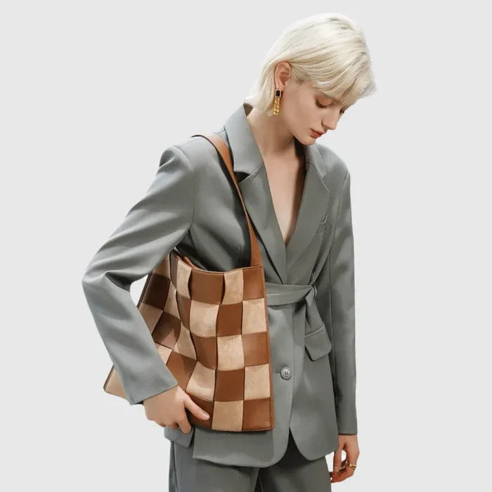 Model styling a brown and tan checkered woven shoulder bag, warm earth-tones suited for urban street style.