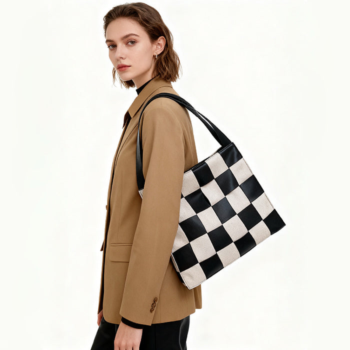 Model wearing a black and white checkered woven leather shoulder bag, ideal for stylish office commuting.