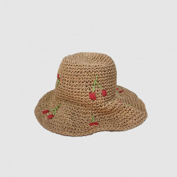 Front view of the khaki straw hat, showing its flexible brim and foldable material.