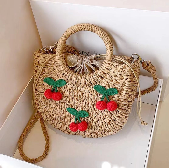 Front view of rattan straw bag with  red cherry appliques and polka dot lining, great for everyday.