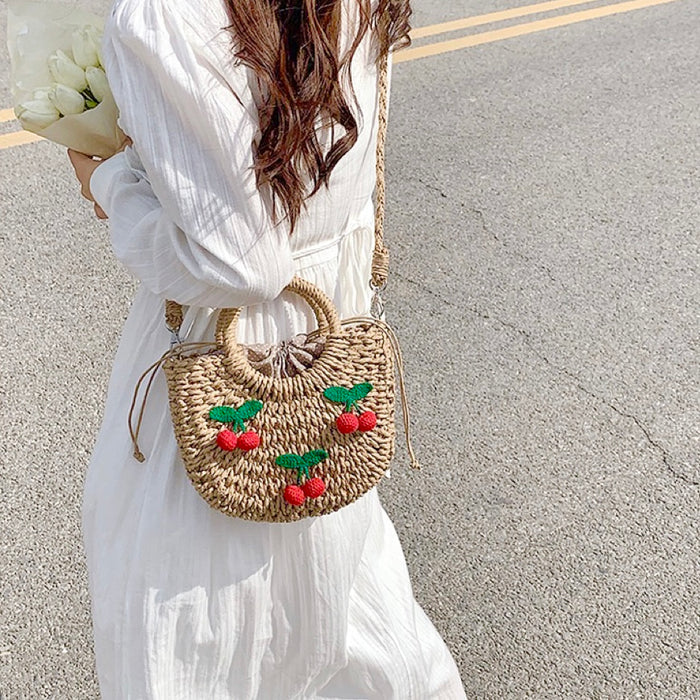 Model carrying a khaki Cherry Rattan Straw Bag as crossbody, ideal for city walks and gifting.