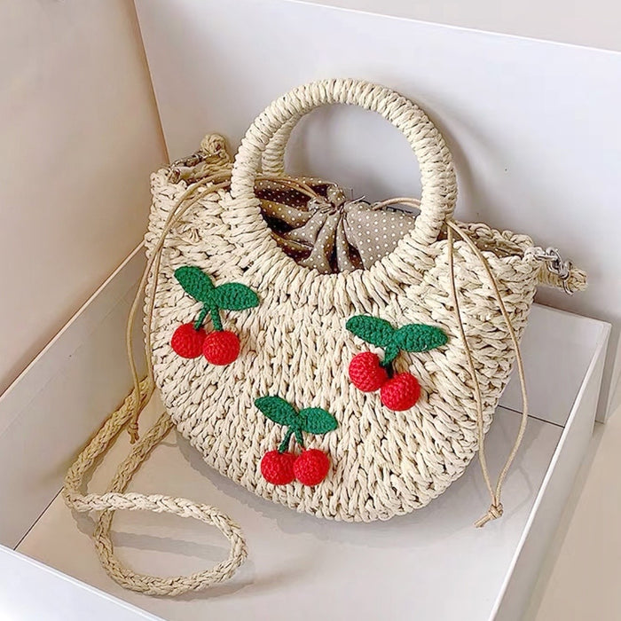 Flat lay of  beige Cherry Rattan Straw Bag, great for everyday carry and travel.