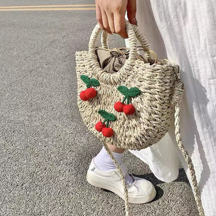 Model carrying a beige Cherry Rattan Straw Bag handheld, ideal for city walks and gifting.