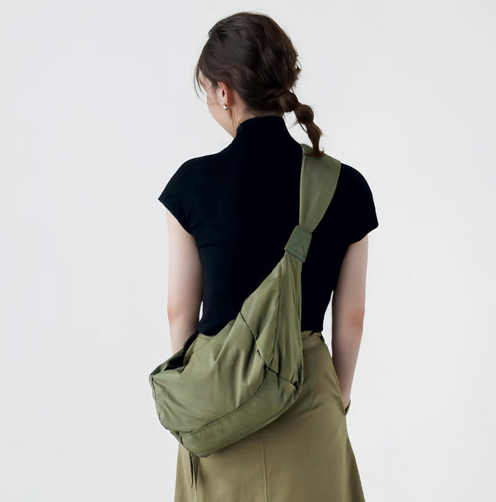 Back view of a model wearing the army green crescent bag as a crossbody.