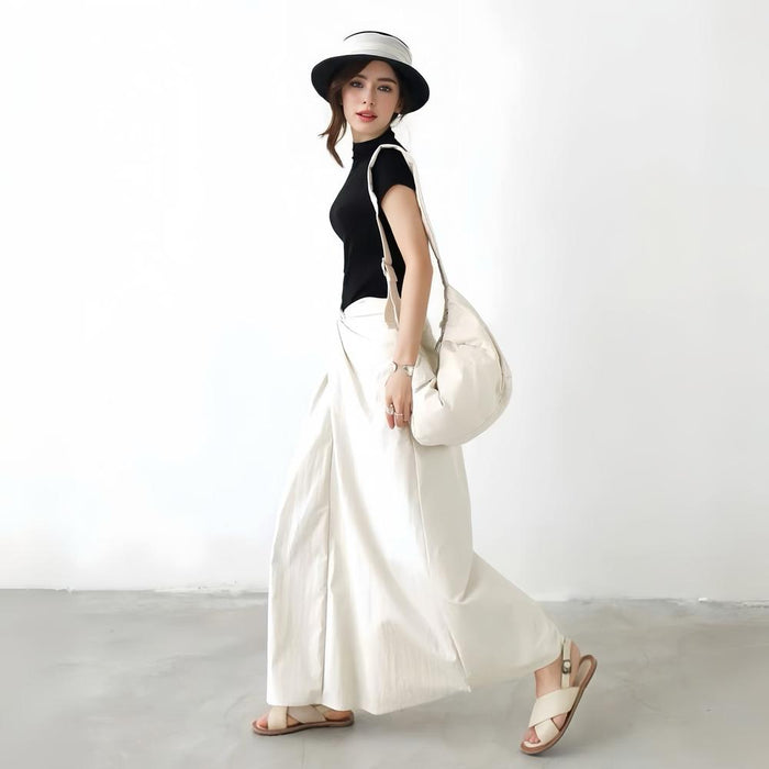 Model walking while wearing the off-white version of the ruched crescent bag.